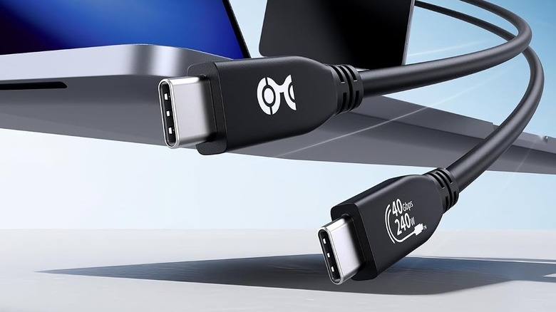 Cable Matters USB4 Cable showing its connectors with part of a laptop in the background