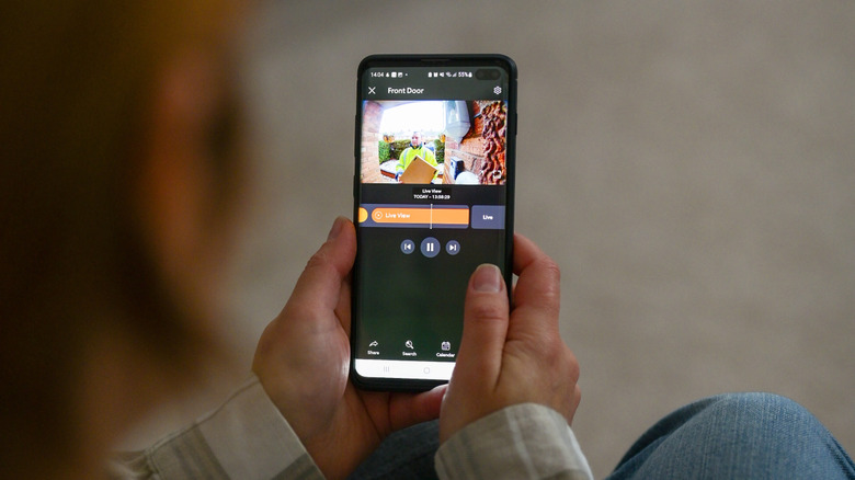A person viewing camera feed from a video doorbell on their smartphone