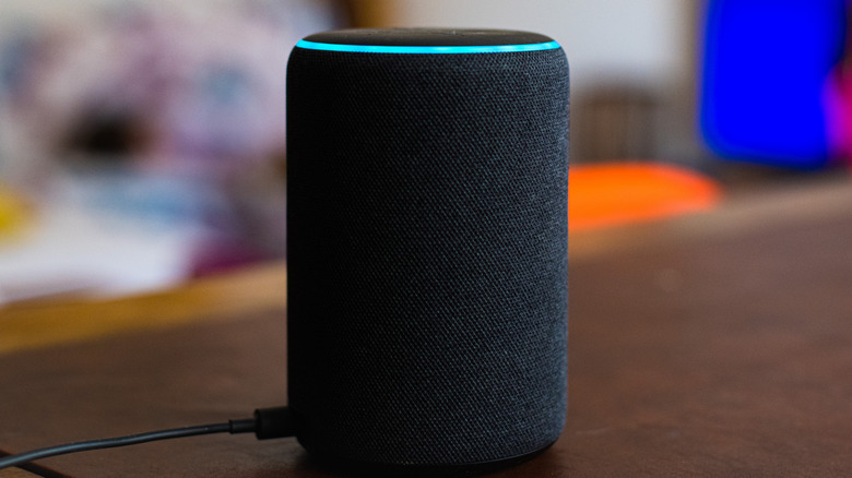 An Alexa device on a wooden surface with a blurred room in the background.