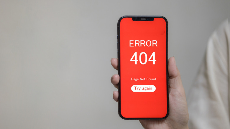 person holding smartphoneshowing error 404 message, buggy page concept