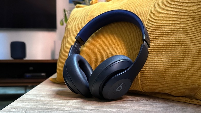 Beats Studio Pro headphones on a bench with a yellow cushion behind them