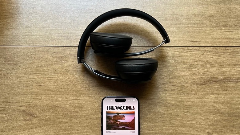 Beats Solo 4 headphones with an iPhone on a table playing a song by The Vaccines