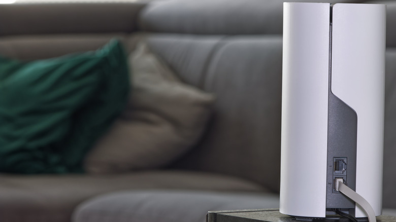 A mesh Wi-Fi system node placed on a sofa side table