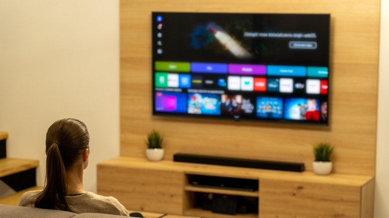 Person on couch watching TV with soundbar