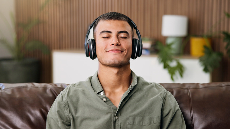 Audiophile listening to headphones on couch