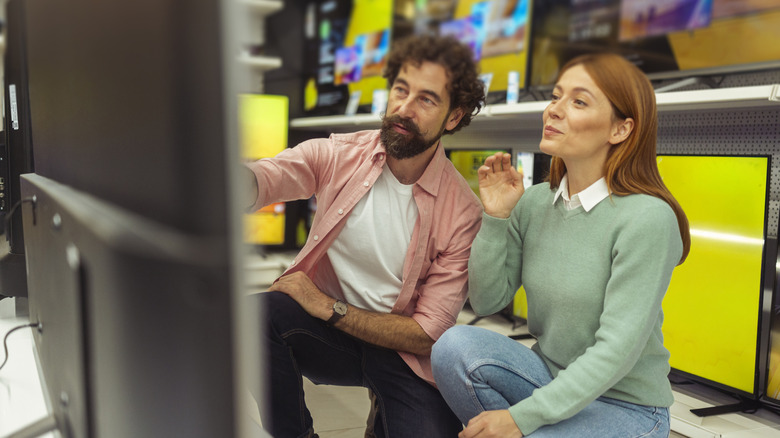 Person admiring TV at electronics store
