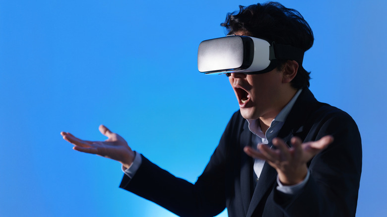A person wearing a VR headset and expressing surprise