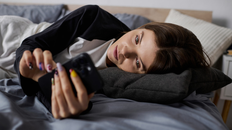 Person using phone in bed