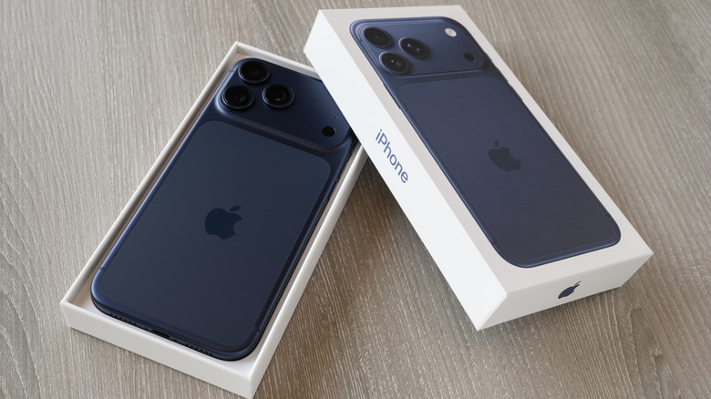 An iPhone 17 Pro Max being unboxed atop a wooden table.