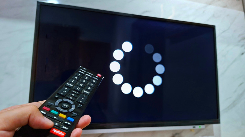 TV showing buffering symbol with the remote control in front of it