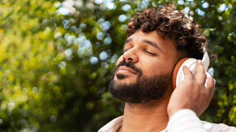 Man listening to headphones with eyes closed