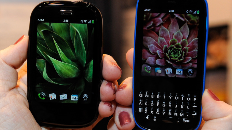 Close-up of a person holding the Palm Pre Plus and Palm Pixi Plus phones