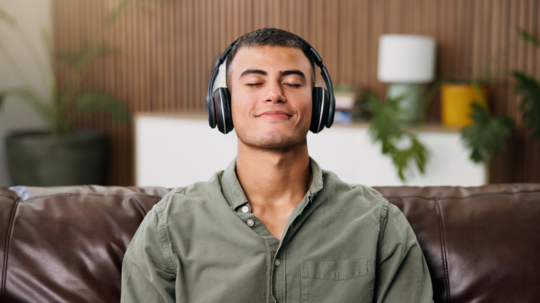 A man using noise-cancelling headphones while at home alone
