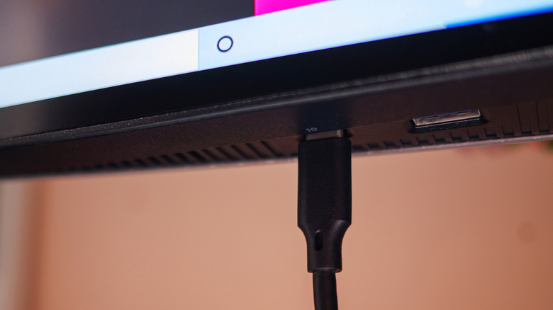 USB Type-C cable plugged into a port on the bottom of a monitor.