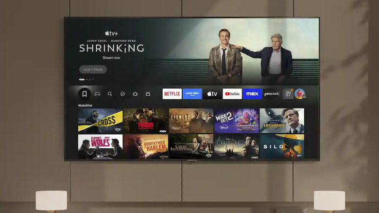 An Insignia TV wall-mounted in a modern living room above a TV stand.