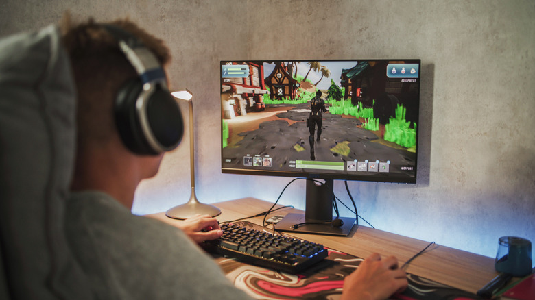 A person wearing headphones while playing a game on a computer