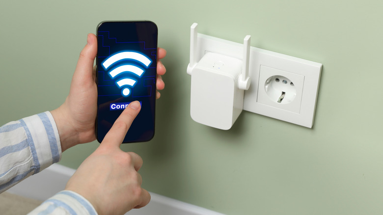 A person connecting to a Wi-Fi extender with a smartphone