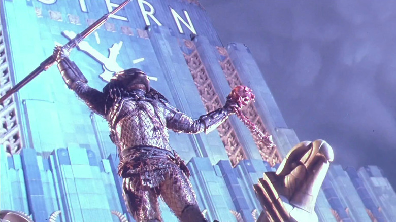 The Predator holding up his spear and celebrating