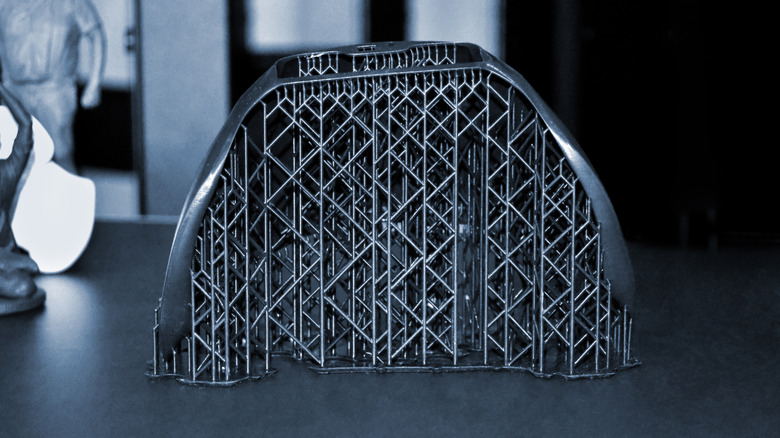 3D printed model with dense support structures still attached.