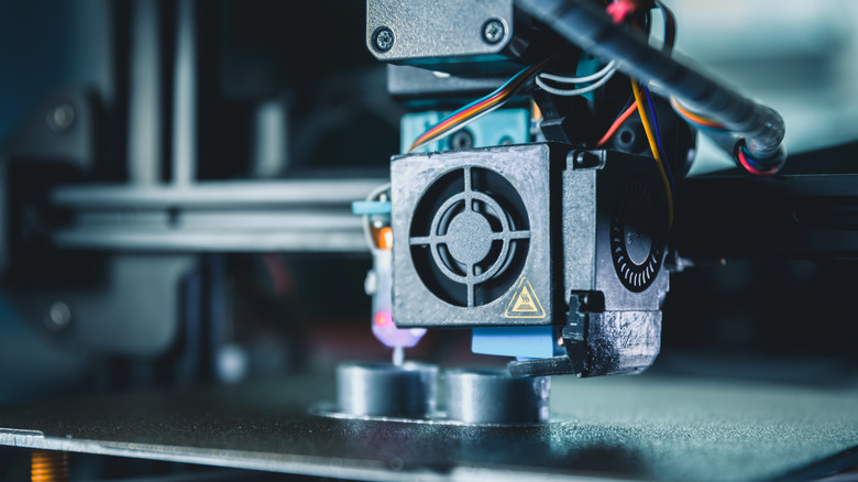 Close-up of a 3D printer extruder printing a small object.