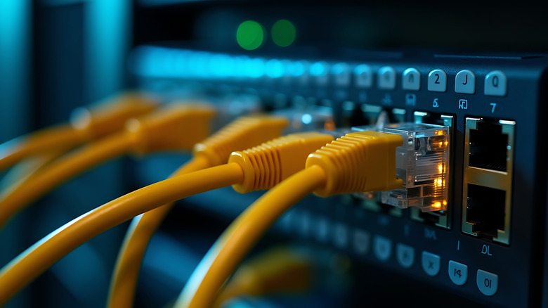 Close up of a network switch with multiple yellow ethernet cables connected for data transfer