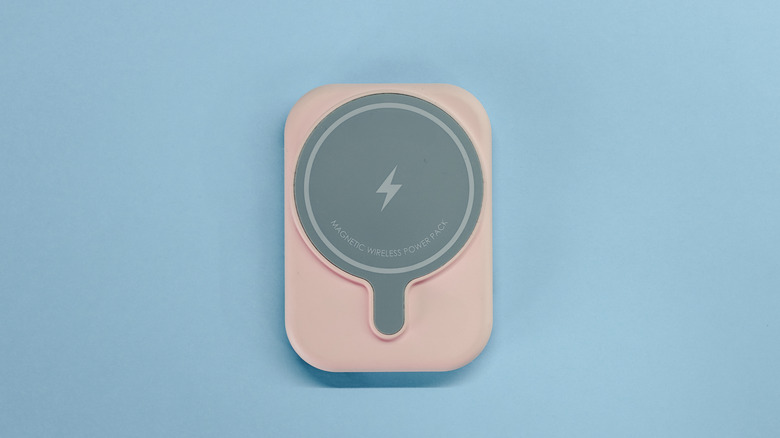 A MagSafe magnetic phone charger on a pastel blue background