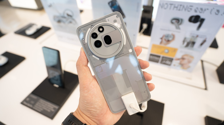 A person holding the Nothing Phone (3) in a retail setting