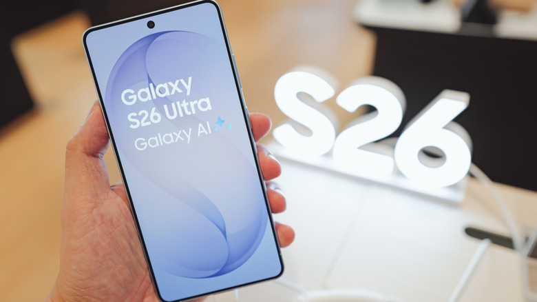 A person holding a Samsung Galaxy S26 Ultra phone in a retail setting