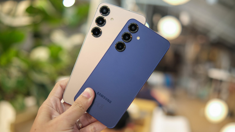 Two Galaxy S25s help up by a hand