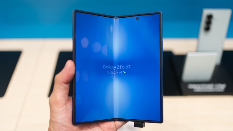 person holding samsung galaxy zfold 7 in a storefront