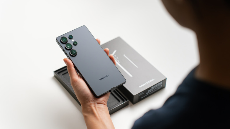 Someone unboxing and holding the Samsung Galaxy S25 Ultra