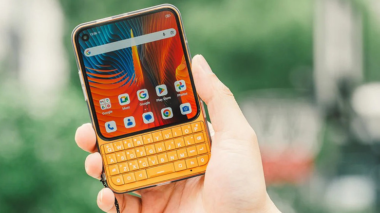 Person holding the orange Unihertz Titan 2 Elite Android phone.