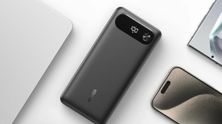 The Anker Travel Essential Power Bank (A1383) placed between a handful of tech devices.