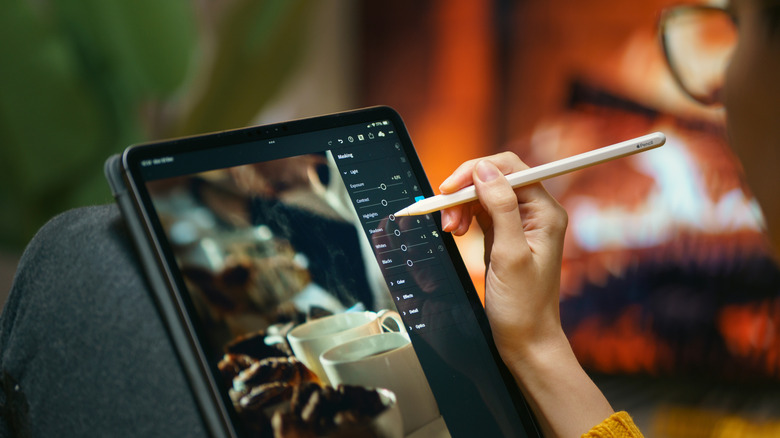 Person using an Apple Pencil to edit an image on an iPad