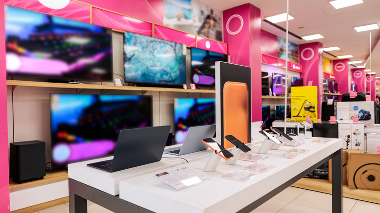 Electronics store with laptops, smartphones, and large-screen TVs.
