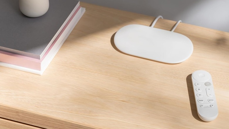 The Google TV Streamer device and remote placed on a wooden surface.