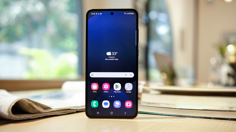A Samsung Galaxy S24 FE phone standing vertical on a desk