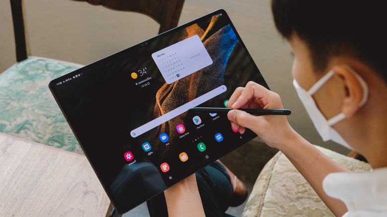 A person navigating a Samsung Galaxy tablet using a stylus