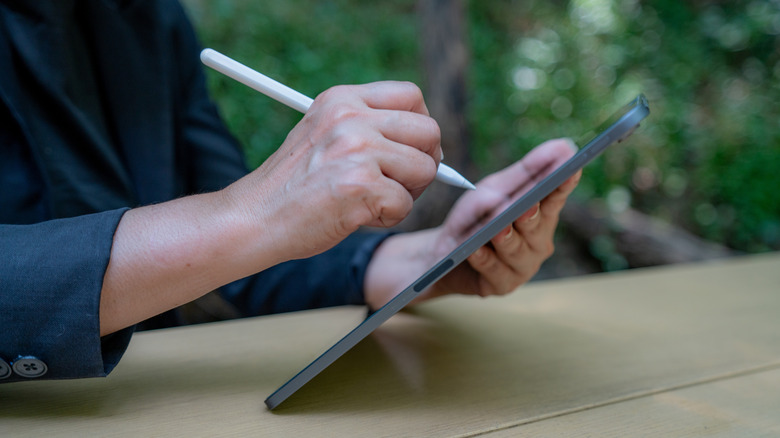 A person using a stylus with a tablet
