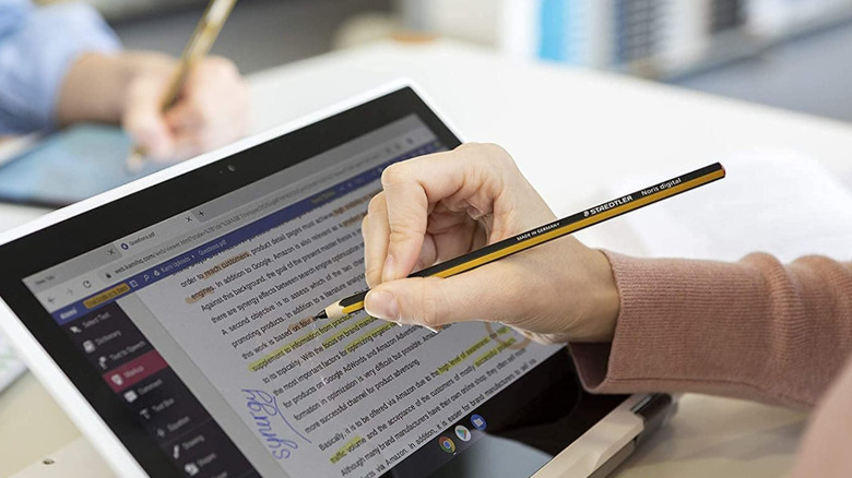 A person using the Staedtler Noris Digital stylus to edit a digital document