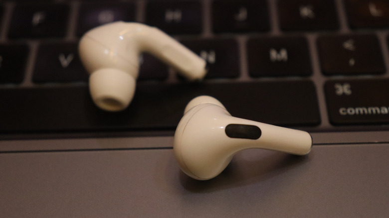 AirPod Pros lying on a MacBook keyboard.