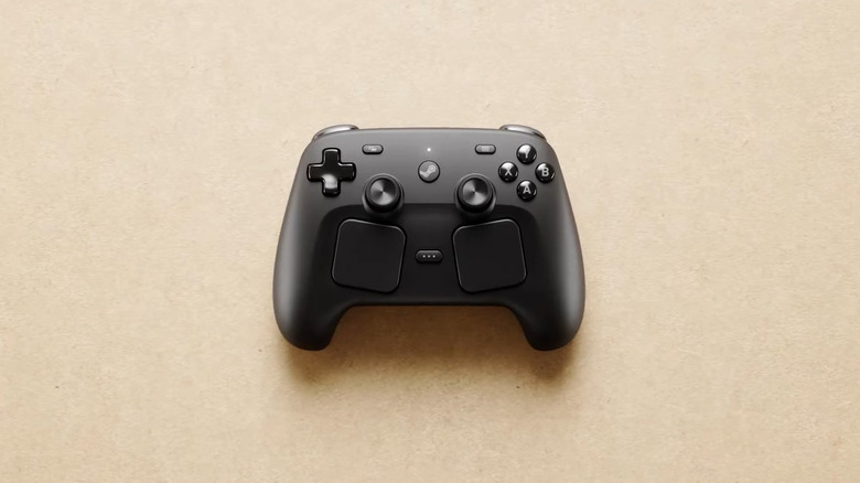 Black Valve Steam Controller on beige surface.