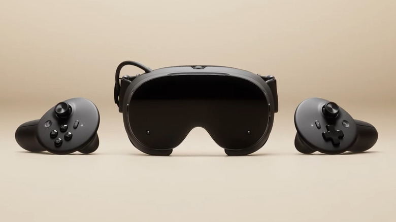 The Steam Frame, a black headset with two controllers on beige surface.