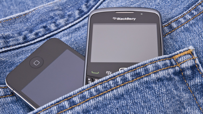 BlackBerry phone and modern smartphone in person's pocket