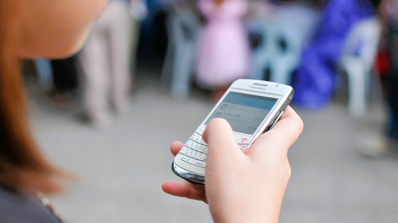 Person typing on BlackBerry device