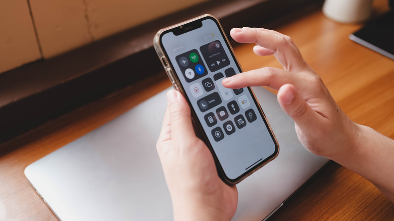 Someone adjusting the brightness in a iPhone's Control Center