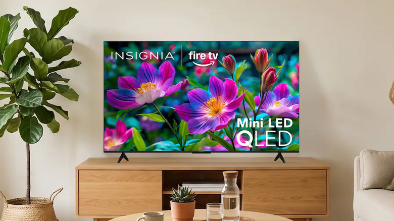 The Insignia F70 4K Mini LED TV set up on a TV stand in a modern living room.