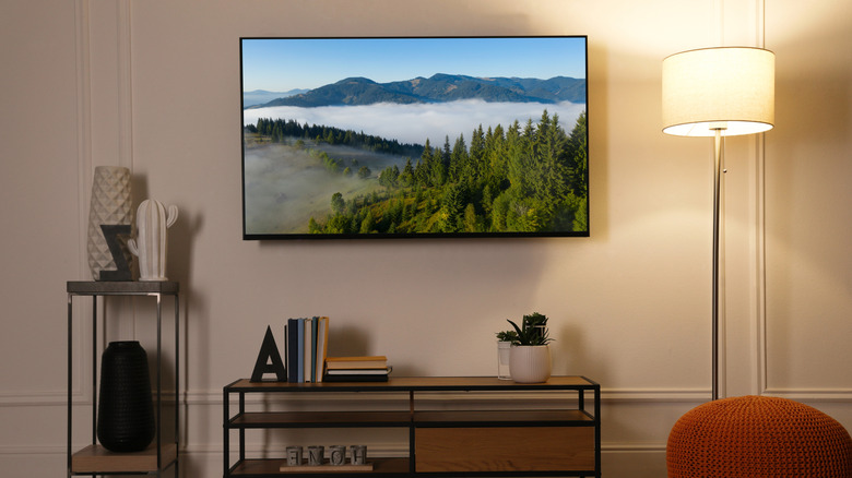 A TV set with a mountain landscape on the screen in a modern living room.