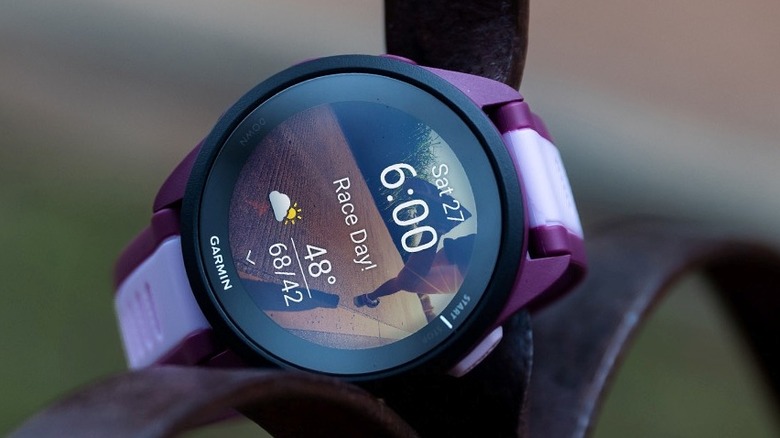 The Garmin Forerunner 165 placed on an iron railing