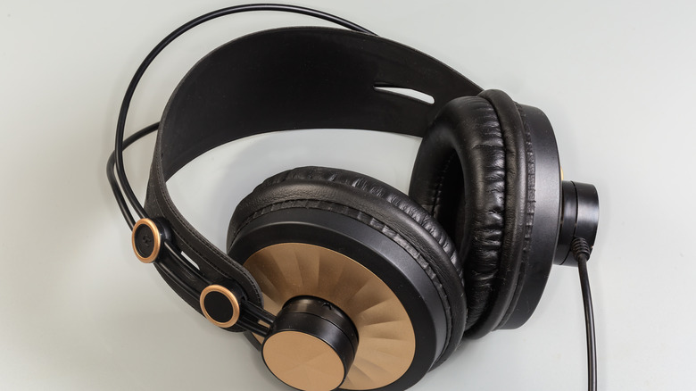 A pair of black and gold wired headphones with a cable coming out of them